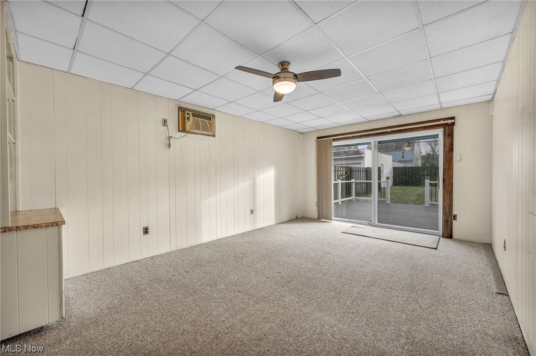 3946 Lansdale Road Cleveland, OH 44118 - Photo 26 of 42 Carpeted Family room featuring ceiling fan, a paneled ceiling, and a wall mounted air conditioner