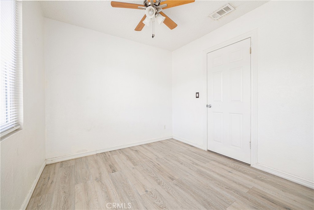 14514 Kennebunk Street Poway, CA 92064 - Photo 13 of 29 an empty room with a ceiling fan and wooden floor