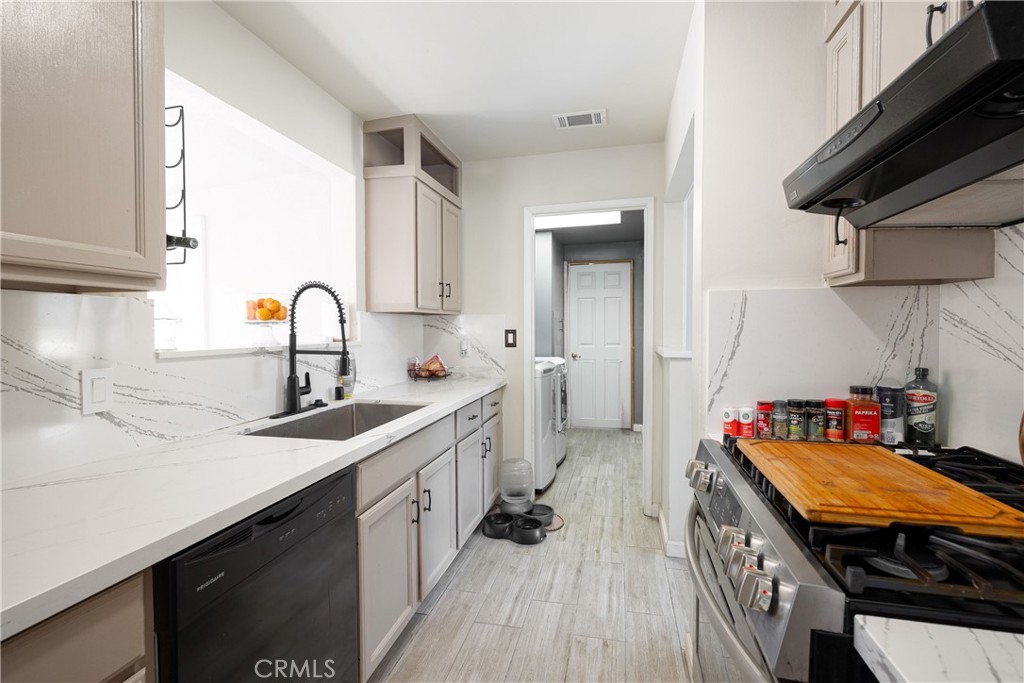14514 Kennebunk Street Poway, CA 92064 - Photo 3 of 29 a kitchen with stainless steel appliances a sink stove top oven and cabinets