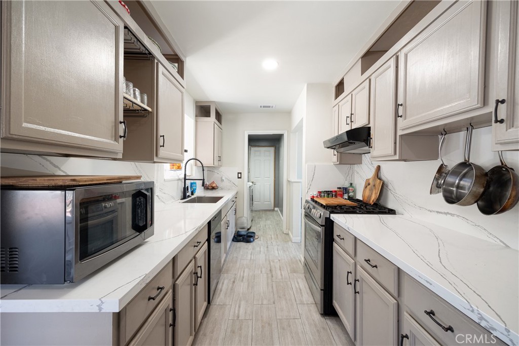 14514 Kennebunk Street Poway, CA 92064 - Photo 4 of 29 a kitchen with stainless steel appliances granite countertop a stove and a sink