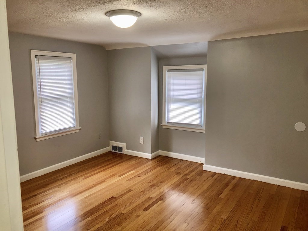 52 Mandalay Road Springfield, MA 01118 - Photo 16 of 24 an empty room with wooden floor and windows