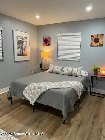 a bedroom with a bed and wooden floor