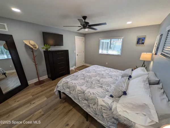 a bedroom with a bed flat screen tv and a dresser