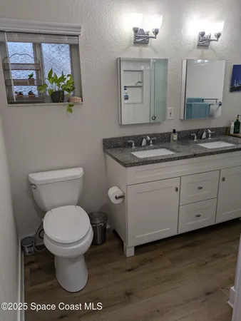 a bathroom with a granite countertop toilet sink and mirror