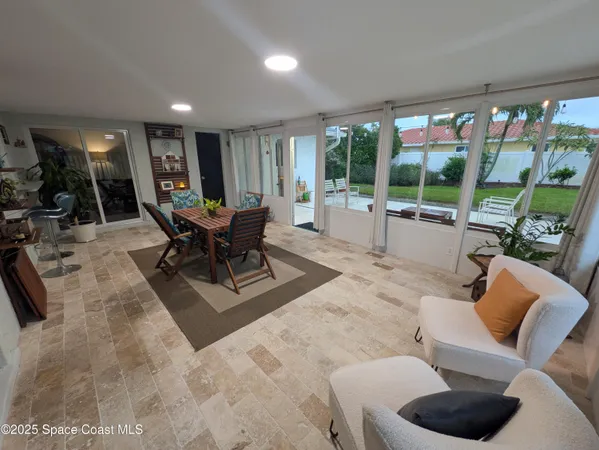 a living room with furniture and a floor to ceiling window