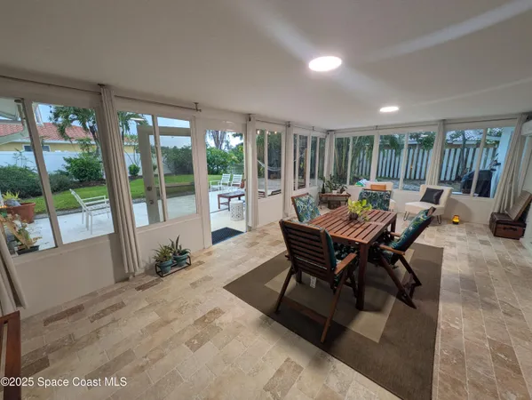 a dining room with furniture and a floor to ceiling window