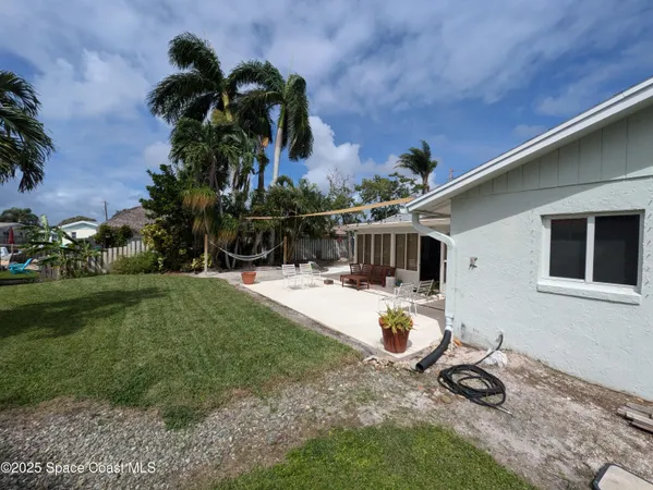 a view of a house with backyard and sitting area