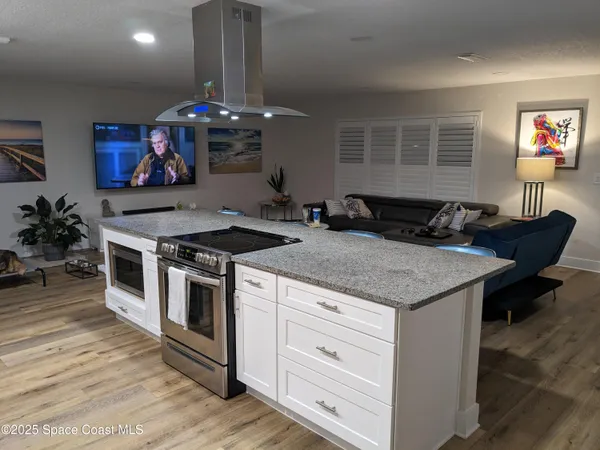 a kitchen with stainless steel appliances granite countertop a stove and a wooden floors