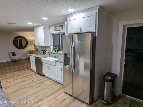a kitchen with kitchen island granite countertop a refrigerator a sink and a stove