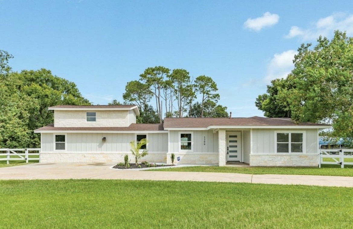 a front view of a house with a garden and yard