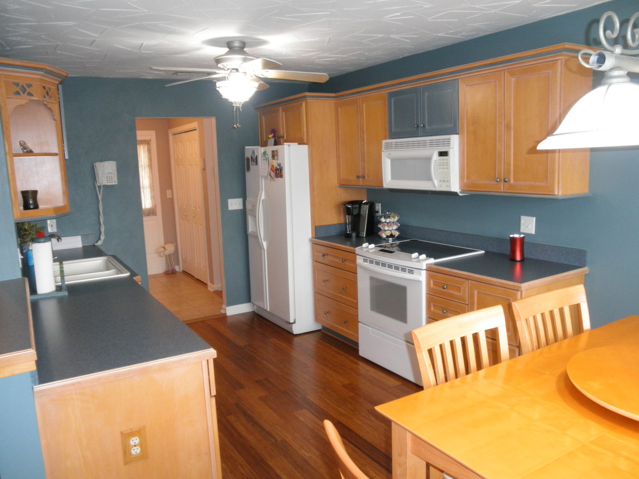 9316 Stewartsville Road Moneta, VA 24121 - Photo 11 of 34 a kitchen with stainless steel appliances a stove a refrigerator a sink a oven with white cabinets and wooden floor
