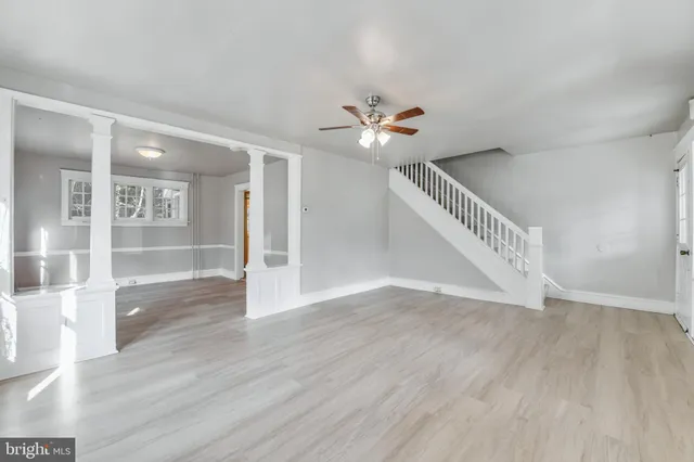 a view of an empty room with a window and wooden floor