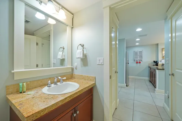 a bathroom with a sink shower and a mirror