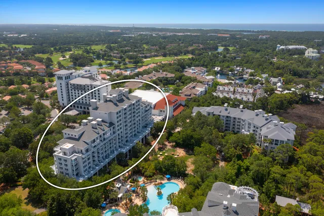an aerial view of a residential houses with outdoor space and ocean view