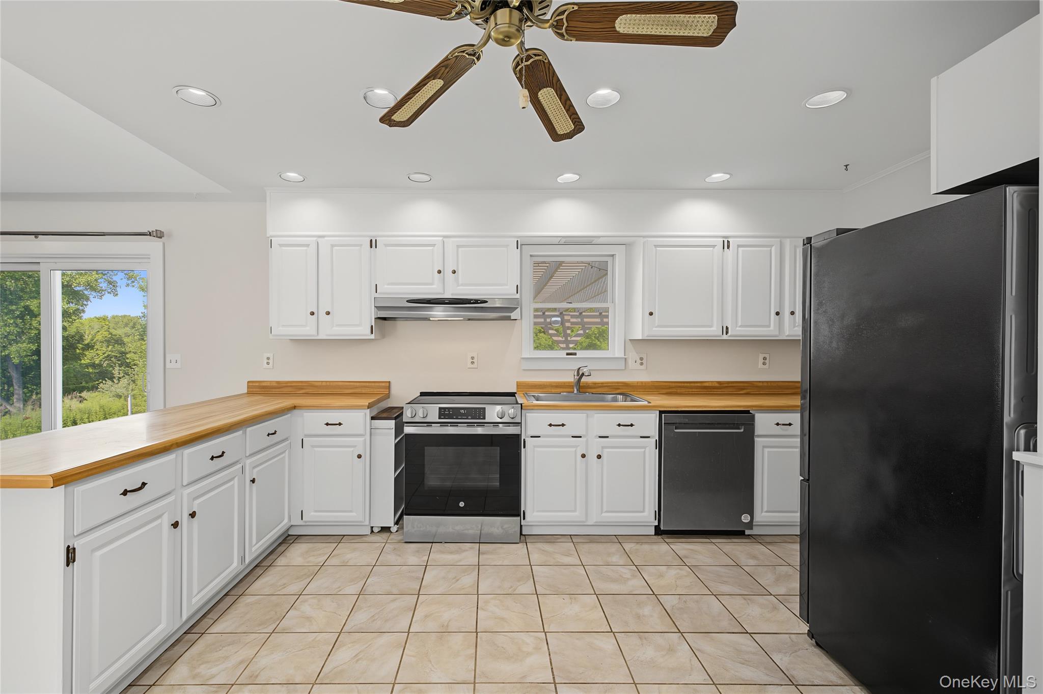 318 Cornwall Hill Road Patterson, NY 12563 - Photo 19 of 38 Bright kitchen featuring white cabinetry, wood-finish countertops, stainless steel appliances, recessed lighting, and a sliding glass door