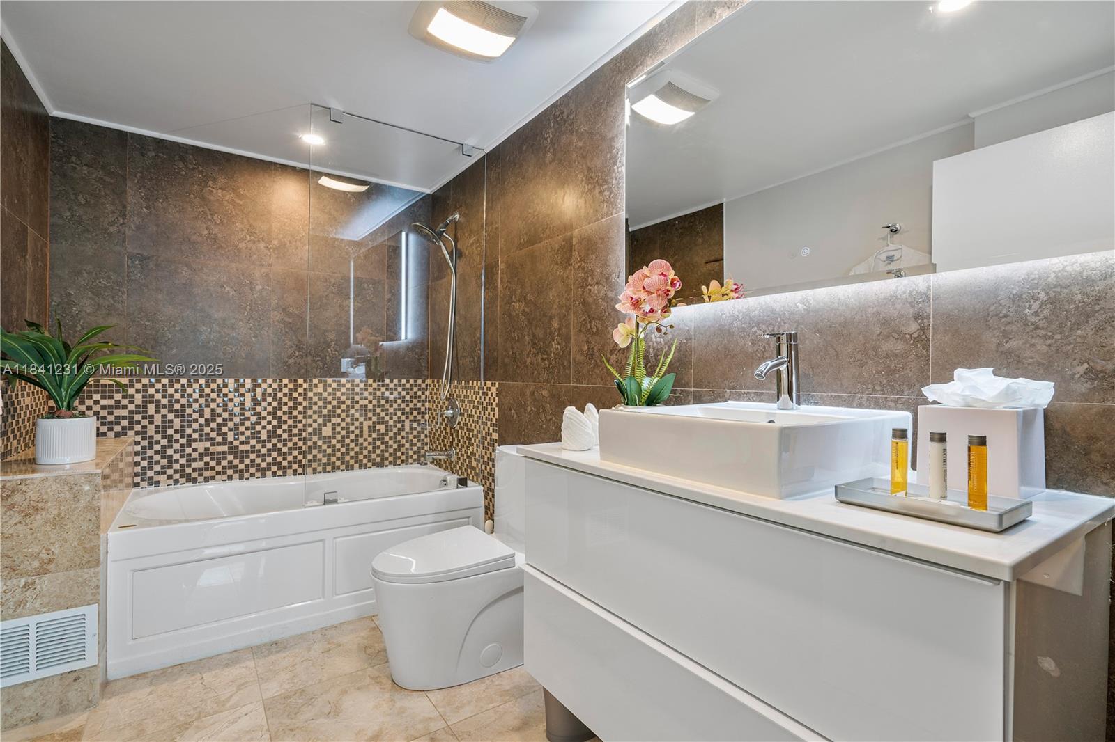 2889 McFarlane Road, Unit 1801 Miami, FL 33133 - Photo 19 of 38 a bathroom with a sink toilet and shower