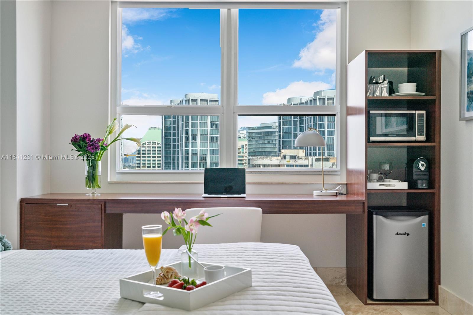2889 McFarlane Road, Unit 1801 Miami, FL 33133 - Photo 31 of 38 a living room with kitchen island furniture and a potted plant