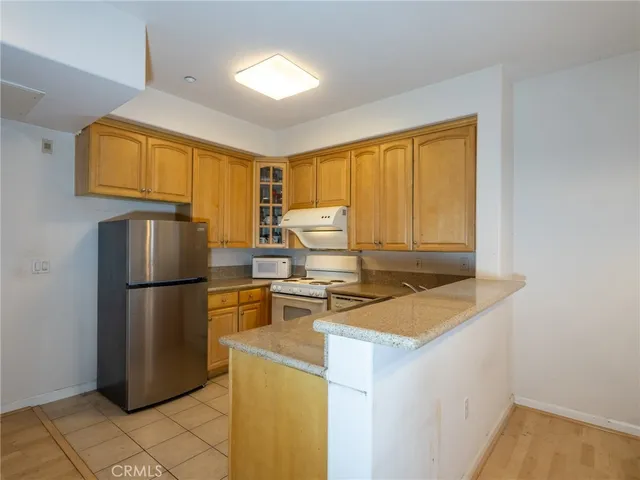 a kitchen with a refrigerator a stove a sink dishwasher and wooden cabinets