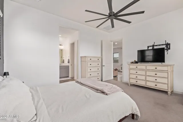a bedroom with a bed and a flat tv screen on dresser
