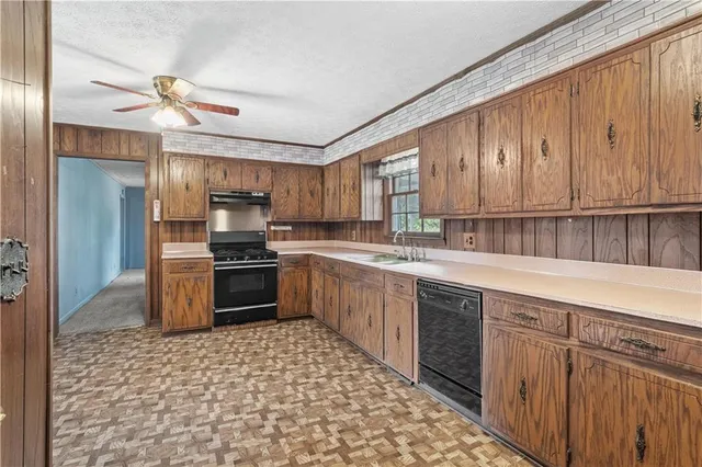 a kitchen with a sink cabinets stainless steel appliances and a counter top space