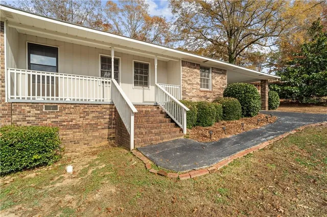a view of a house with backyard and trees