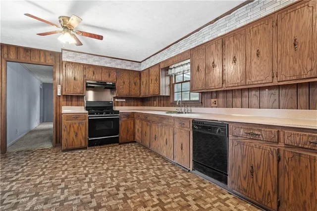 a kitchen with a sink cabinets stainless steel appliances and a window