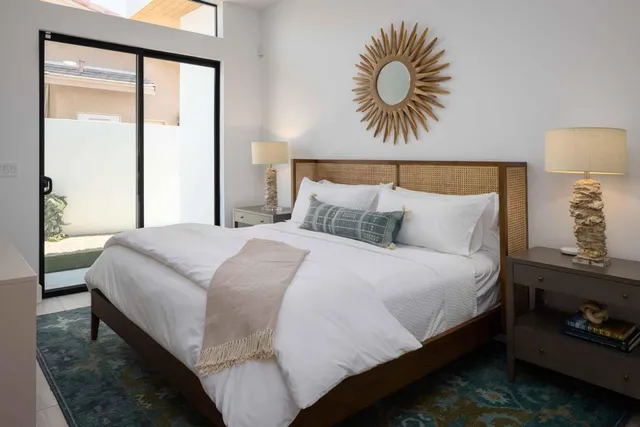 a spacious bedroom with a bed and glass window