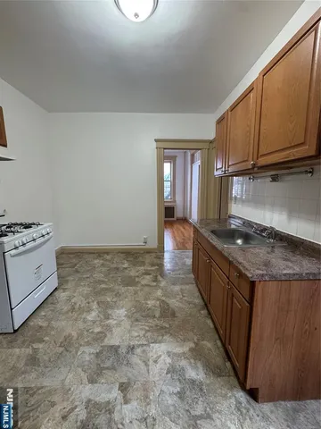 a large kitchen with granite countertop a stove top oven a sink and dishwasher