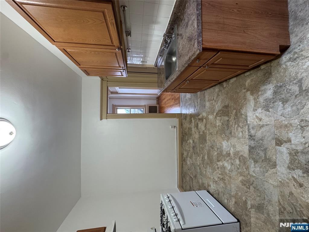 43 66th Street West New York, NJ 07093 - Photo 2 of 8 a large kitchen with granite countertop a stove top oven a sink and dishwasher