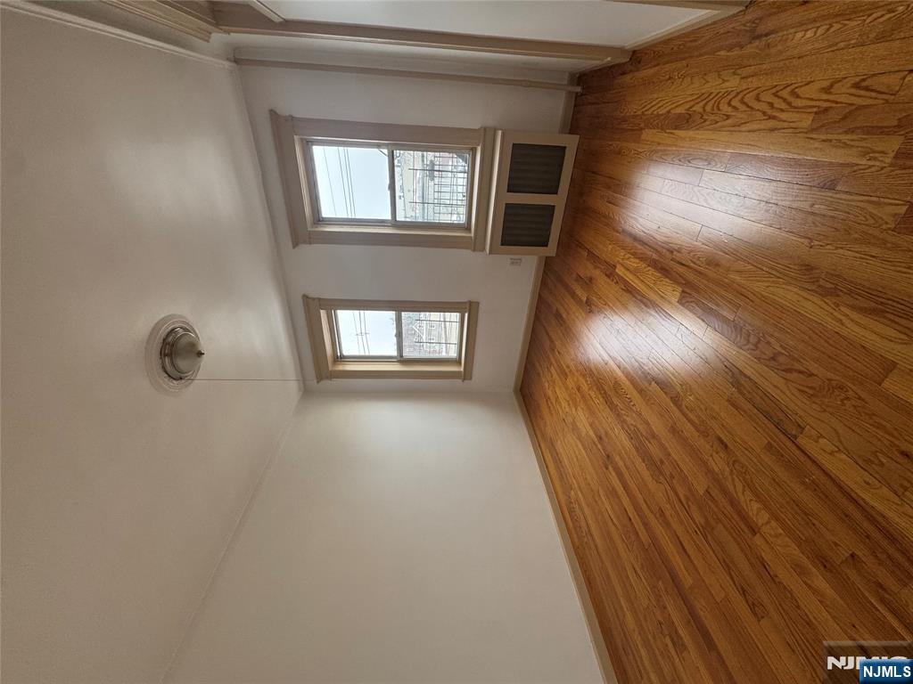 43 66th Street West New York, NJ 07093 - Photo 6 of 8 an empty room with wooden floor and windows