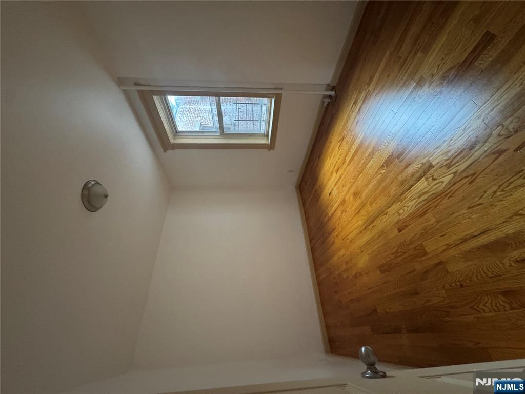 43 66th Street West New York, NJ 07093 - Photo 7 of 8 an empty room with wooden floor and windows