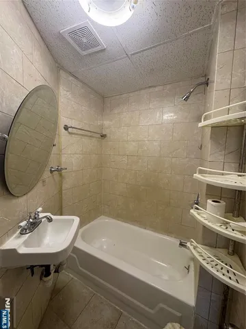 a bathroom with a sink shower and a mirror