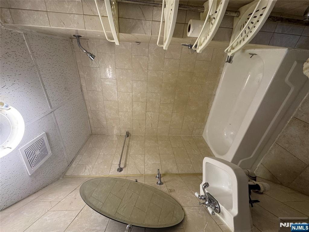 43 66th Street West New York, NJ 07093 - Photo 8 of 8 a bathroom with a sink shower and a mirror