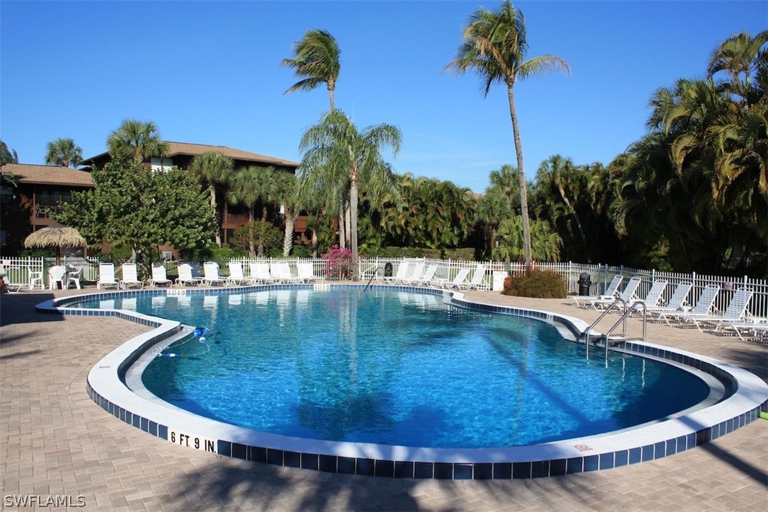 5117 Sea Bell Road, Unit F108 Sanibel, FL 33957 - Photo 15 of 17 a view of a swimming pool with a yard and palm trees