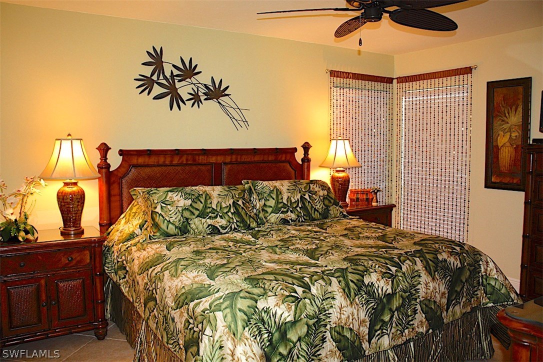 5117 Sea Bell Road, Unit F108 Sanibel, FL 33957 - Photo 6 of 17 a bed sitting in a bedroom next to a window with a chandelier