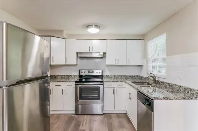 a kitchen with a stove sink and refrigerator