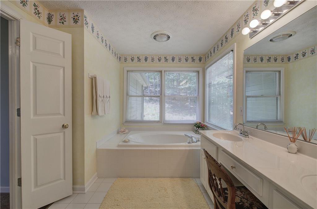 1379 Little Hendricks Mountain Road Jasper, GA 30143 - Photo 25 of 56 a bathroom with a tub a sink and a mirror