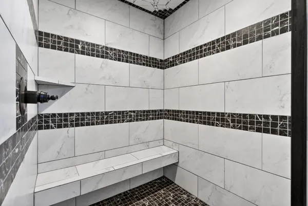 a bathroom with a shower a sink and a mirror