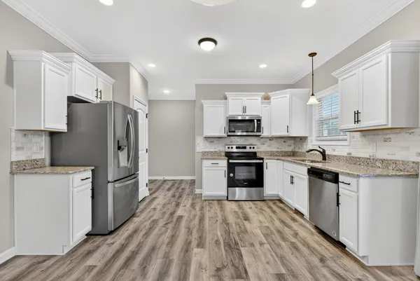 a kitchen with stainless steel appliances a refrigerator sink and stove