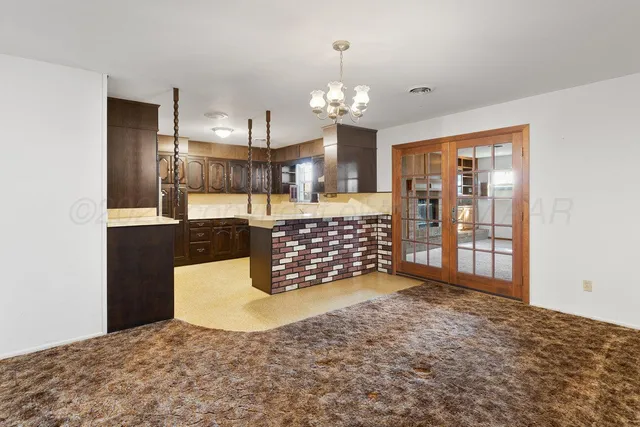 a living room with furniture a chandelier and a dining table