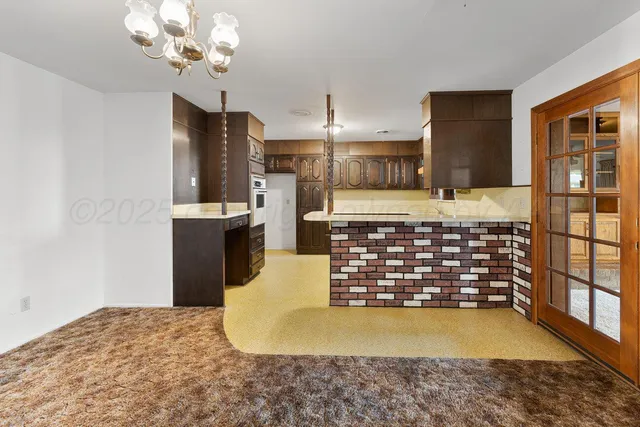a view of a kitchen with kitchen island a sink stainless steel appliances and cabinets