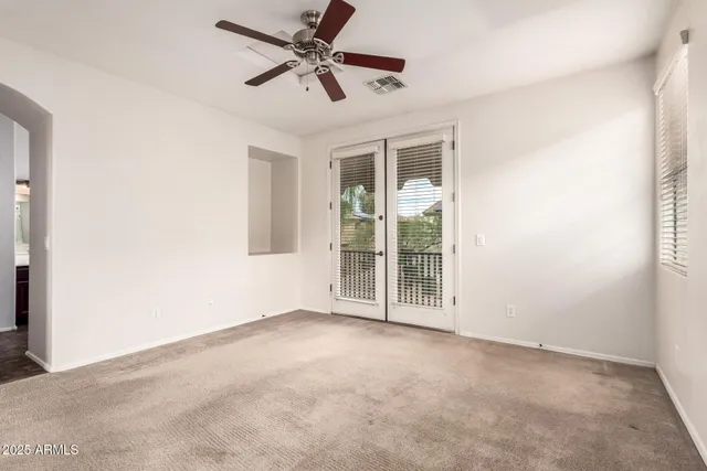 an empty room with chandelier fan