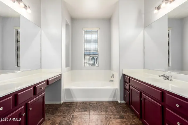 a bathroom with a tub sink and mirror
