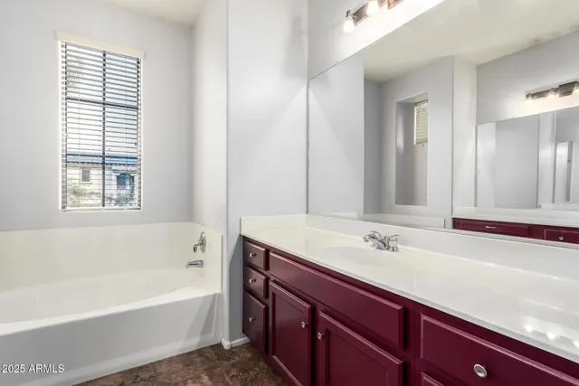 a bathroom with a tub sink and mirror