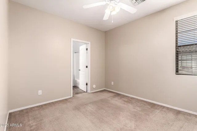 an empty room with a chandelier fan