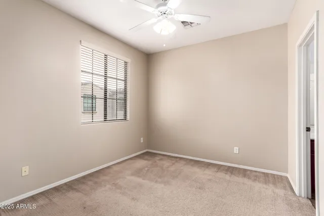 an empty room with a window and a fan