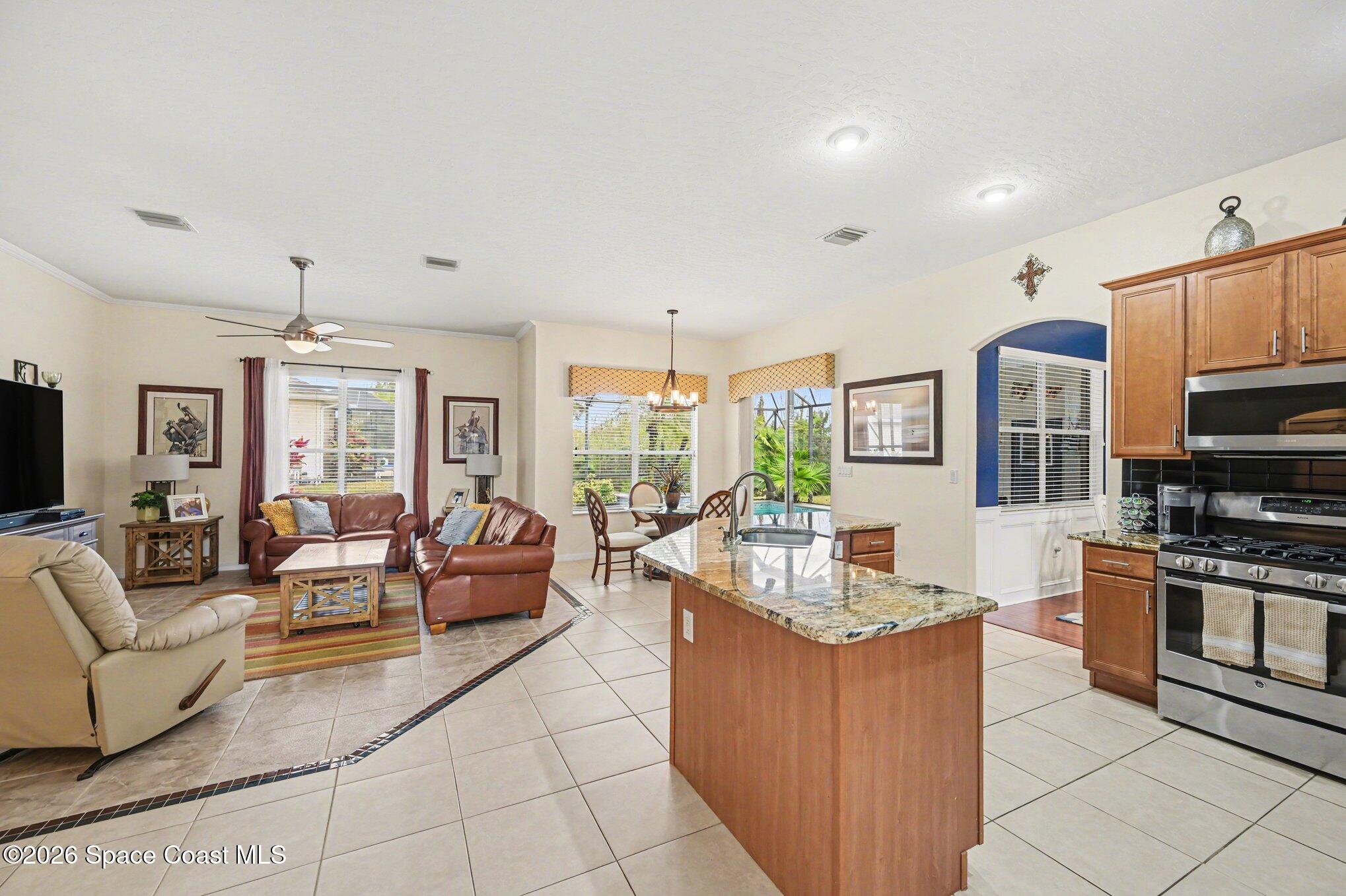 3760 Fringetree Lane Melbourne, FL 32940 - Photo 17 of 36 a living room with furniture a flat screen tv and kitchen view