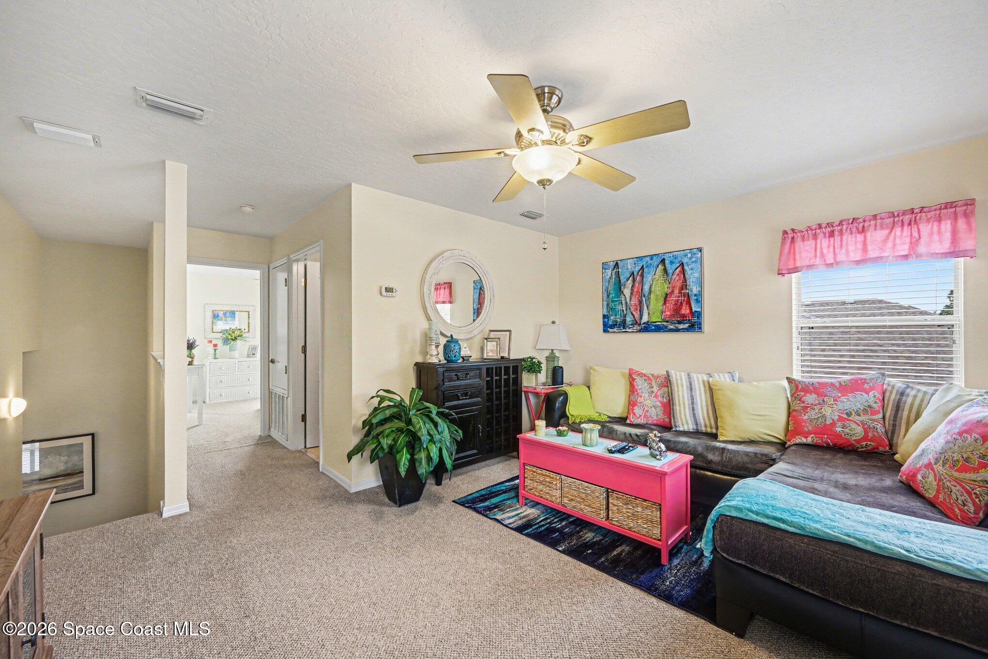 3760 Fringetree Lane Melbourne, FL 32940 - Photo 33 of 36 a living room with furniture and a chandelier