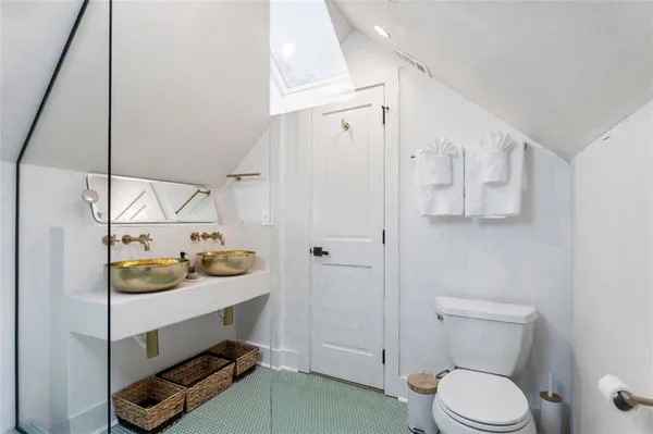 a bathroom with a granite countertop sink a toilet and shower