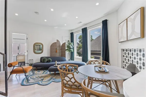 a living room with furniture a large window and dining table